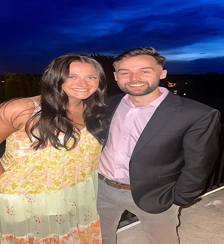 Man and women smiling for camera during night time