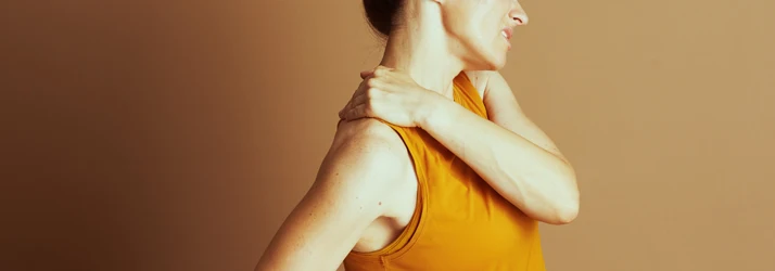 Woman Wrapping Her Arm Around Her Body to Grab Her Opposite Shoulder